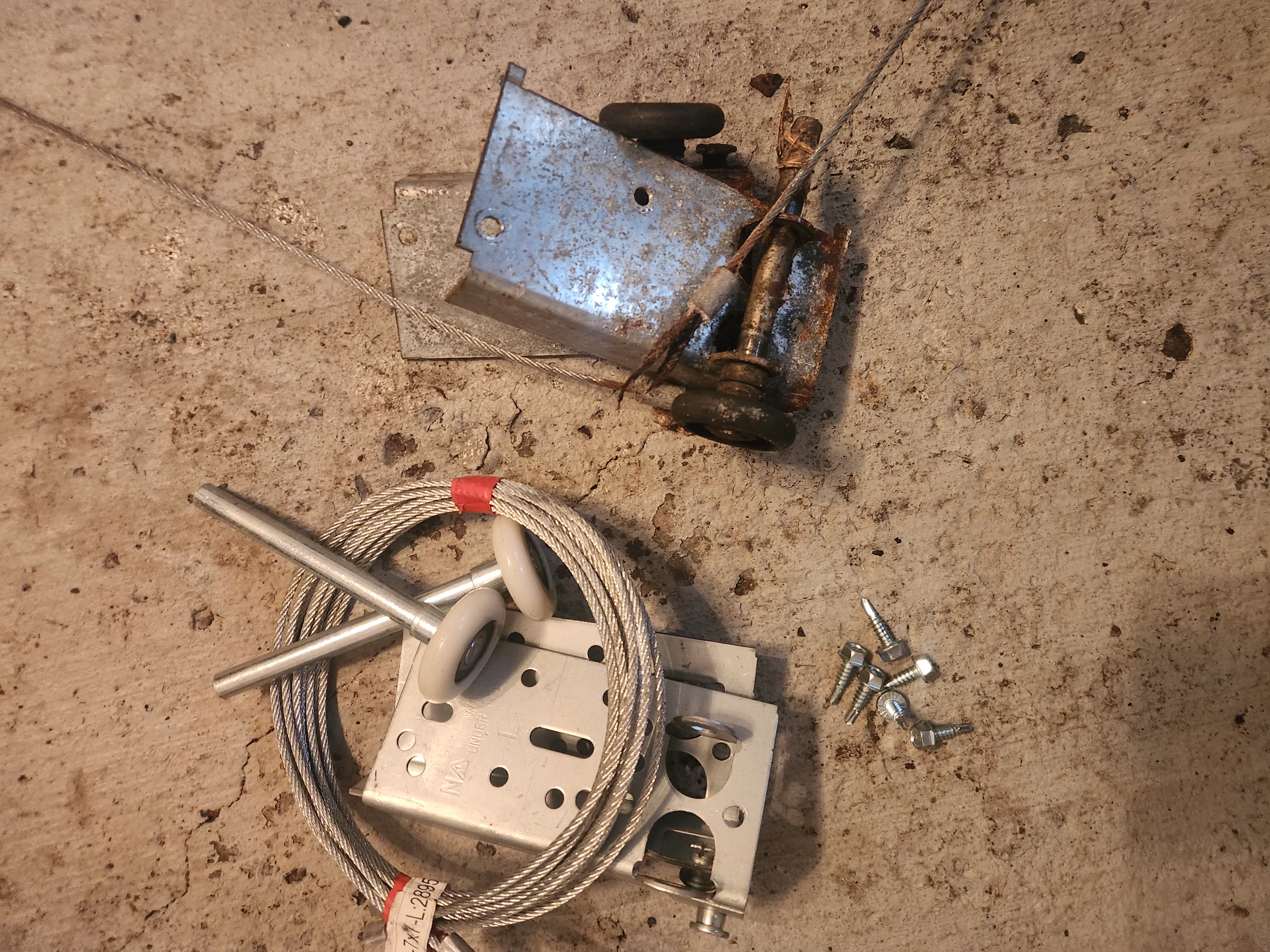 New garage door lift cables, nylon rollers, and bottom bracket ready for install in Stittsville
