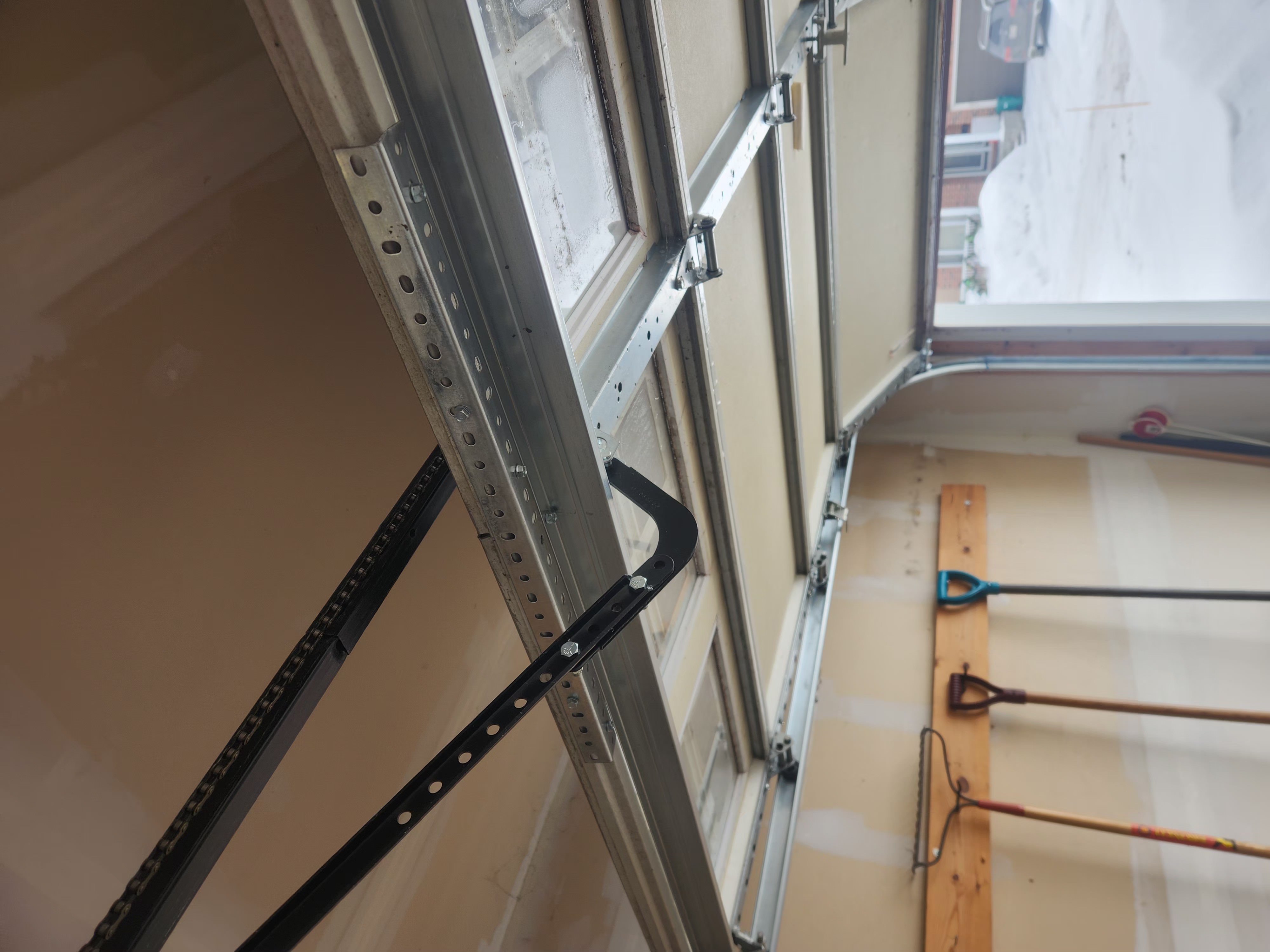 Garage door horizontal struts and reinforcement bracket installed across the top panel in Stittsville