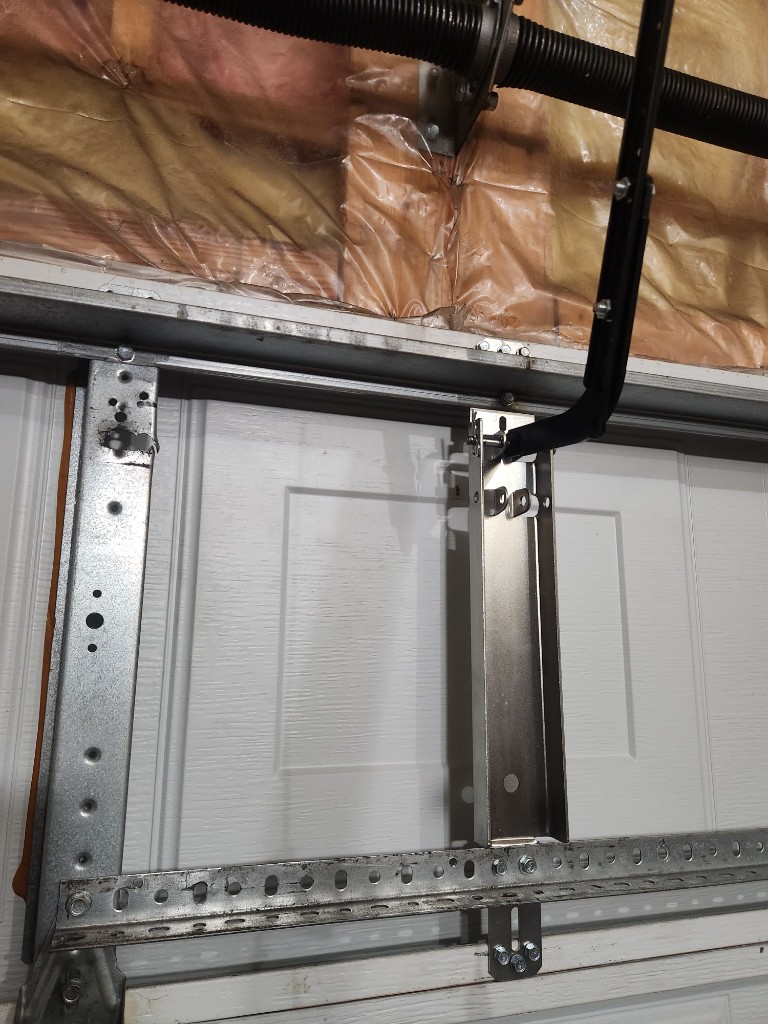 New top-panel strut and vertical reinforcement bracket on a white insulated Stittsville garage door